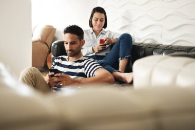 Mutlu İspanyol çift akıllı telefonlar koltukta evde kullanma