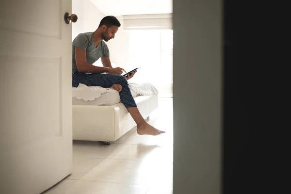 Hispánský muž sledujete film na tabletu v posteli — Stock fotografie