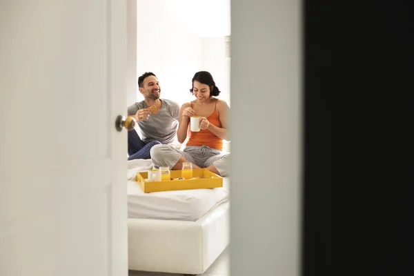 Marido feliz e esposa comer café da manhã na cama — Fotografia de Stock