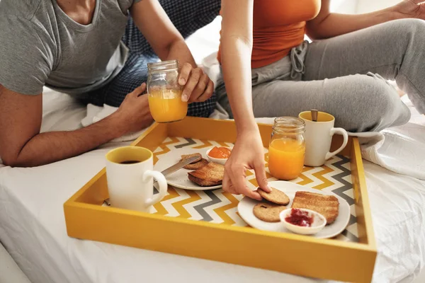 Marido feliz y esposa comiendo desayuno en la cama — Foto de Stock