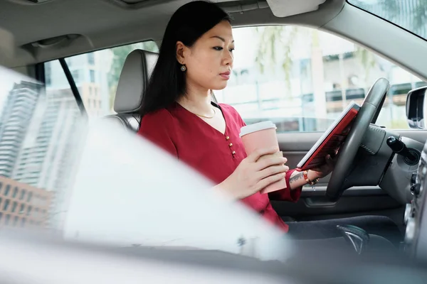 타블렛으로 자동차에서 일 하는 바쁜 중국 사업 여자 — 스톡 사진