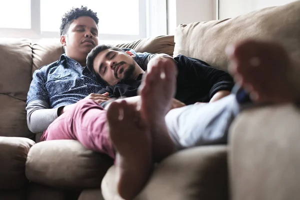 Νέοι ομοφυλόφιλοι άνδρες στον ύπνο και να χαλαρώσετε στον καναπέ στο σπίτι — Φωτογραφία Αρχείου