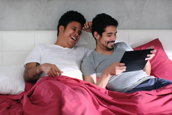 同性恋男子玩视频与伙伴在床上 — 图库照片