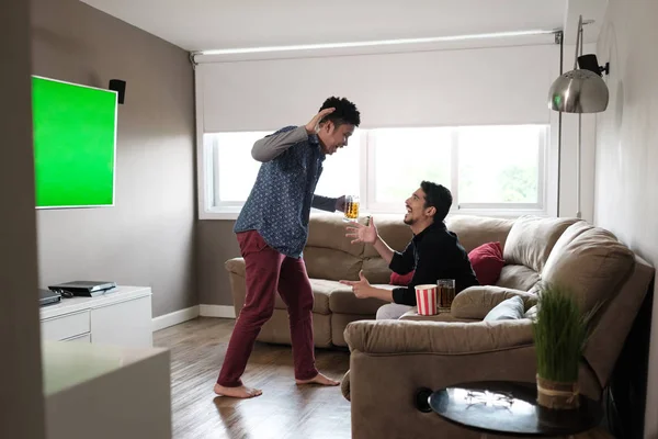 Ευτυχισμένο ζευγάρι Gay βλέποντας αθλητικό παιχνίδι στην τηλεόραση στο σπίτι — Φωτογραφία Αρχείου