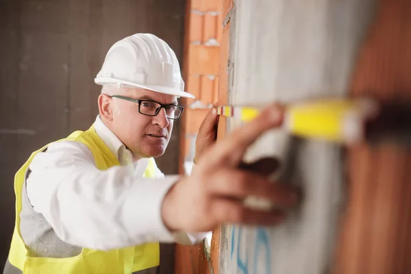 Man arbetar som arkitekt mäta vägg i byggarbetsplatsen — Stockfoto