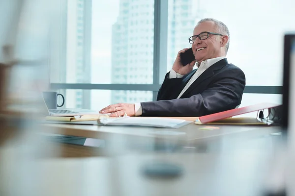 Empresário trabalhando no escritório com computador e conversando no telefone — Fotografia de Stock