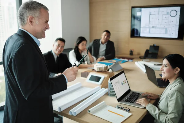 Arquiteto mostrando prédio em miniatura em reunião de negócios com o cliente — Fotografia de Stock