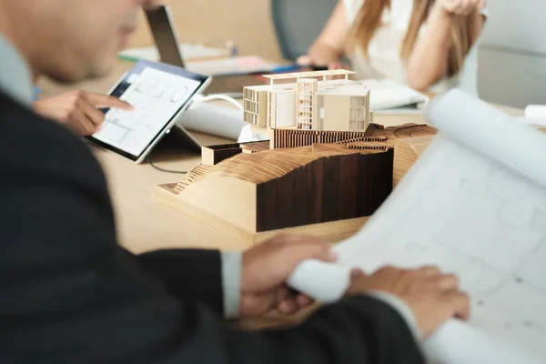 Miniature Building At Business Meeting With Architect Looking at Blueprints — Stockfoto