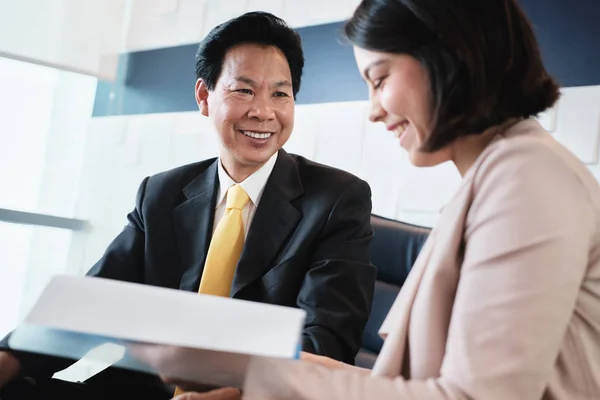 Anlageplaner zeigt asiatischen Kunden Dokumente in Bank — Stockfoto