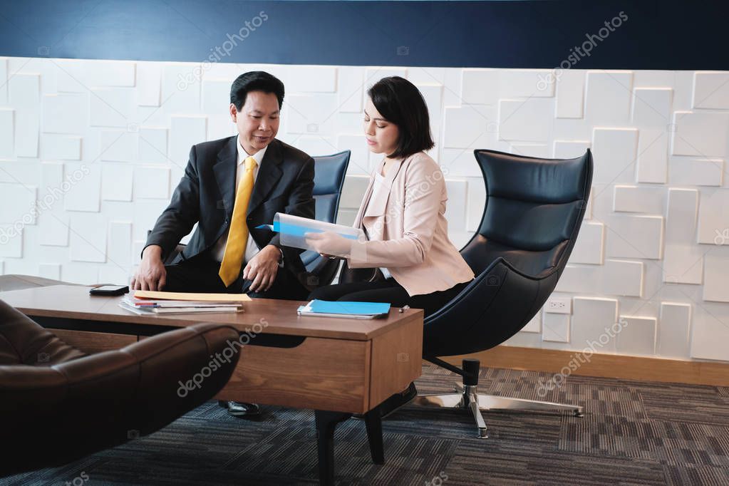 Investment Plan Agent Showing Documents To Asian Customer In Bank