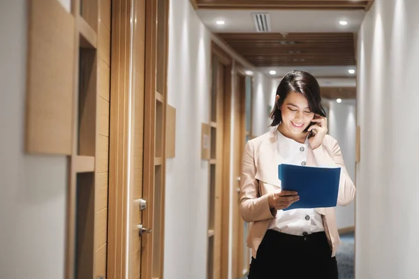 Giovane donna d'affari che lavora nell'agenzia finanziaria parlando sul cellulare — Foto Stock