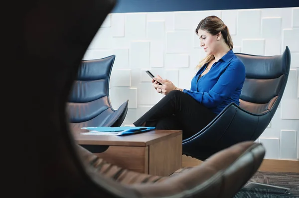 사무실 대기실에 앉아 스마트폰으로 심각한 비즈니스 우먼 — 스톡 사진