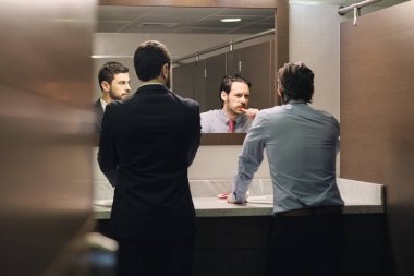İş adamı fırçalama diş öğle yemeğinden sonra Office banyoda zorla