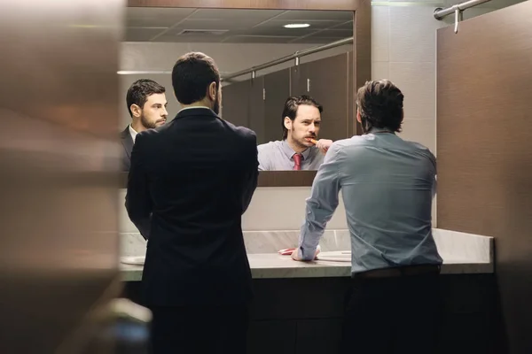 Geschäftsmann beim Zähneputzen nach der Mittagspause im Büro-Badezimmer — Stockfoto