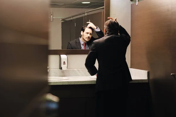 Spaanse zakenman haarlijn In Office toiletten kijken bezorgd — Stockfoto