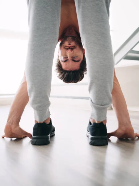 Uomo che pratica lo yoga a casa facendo routine di saluto al sole — Foto Stock