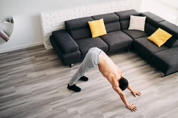 Hombre practicando yoga en casa haciendo rutina de saludo al sol — Foto de Stock