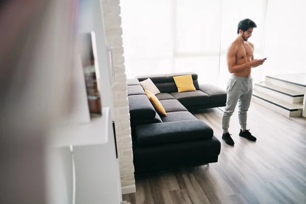 Homem trabalhando em casa com o aplicativo no telefone móvel — Fotografia de Stock