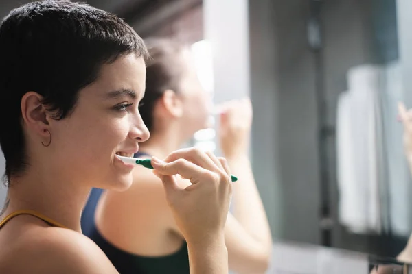 Mulheres lésbicas que vivem juntas escovando dentes no banheiro em casa — Fotografia de Stock
