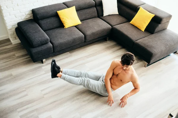 Adulto homem formação ABS músculos em casa fazendo russo torção exercício — Fotografia de Stock