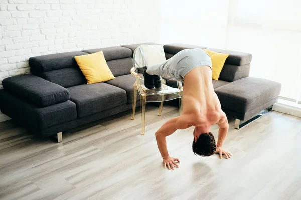 Dorosły człowiek trening mięśnie klatki piersiowej w domu robi pompki skłonni — Zdjęcie stockowe