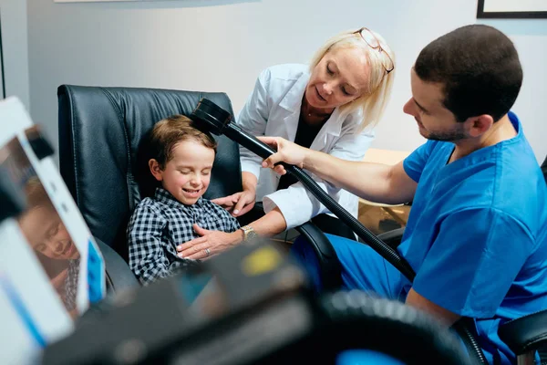 Врач-педиатр проводит лечение мозга ребенка-аутиста в клинике — стоковое фото