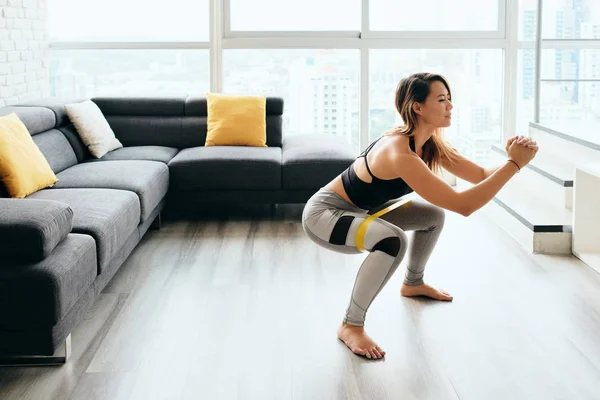 Adulto mulher formação pernas fazendo lado agachamento em casa — Fotografia de Stock