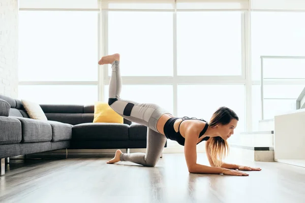 Dorosły kobieta szkolenia nogi i z powrotem robi Plank osioł kicks — Zdjęcie stockowe
