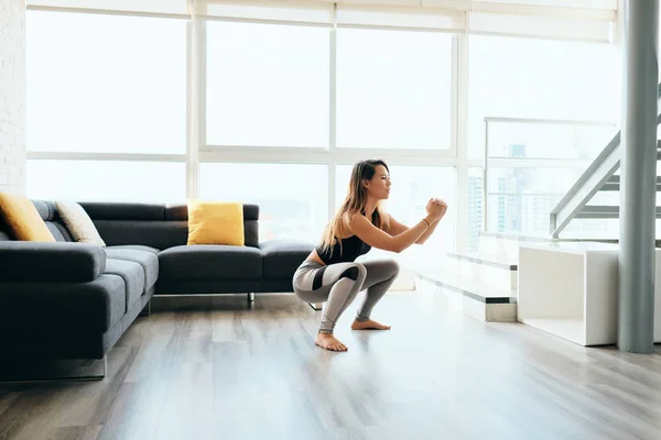 Erwachsene Frau trainiert Beine machen in und aus Kniebeuge — Stockfoto