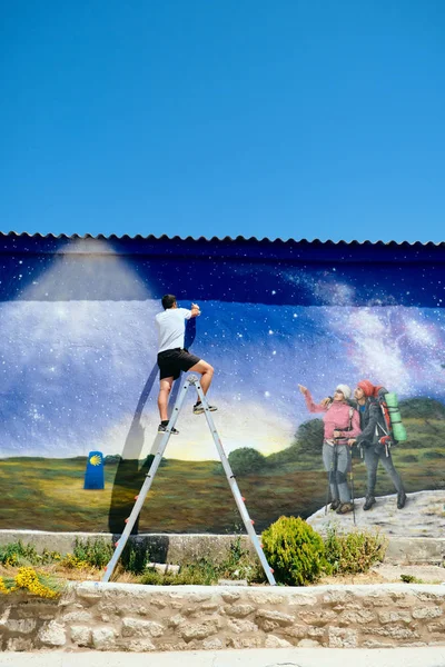 Man målning graffiti längs Camino de Santiago — Stockfoto
