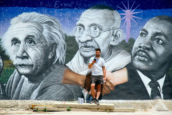 Человек рисует граффити вдоль Камино де Сантьяго
