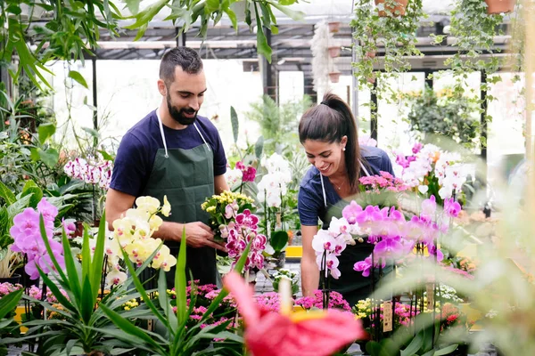 Lavoro di squadra con i collaboratori felici al lavoro nel negozio di fioristi — Foto Stock