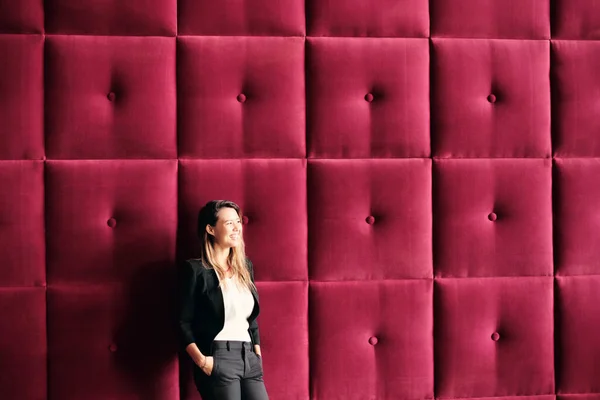 Joven mujer de negocios de pie contra paneles de pared de Borgoña — Foto de Stock