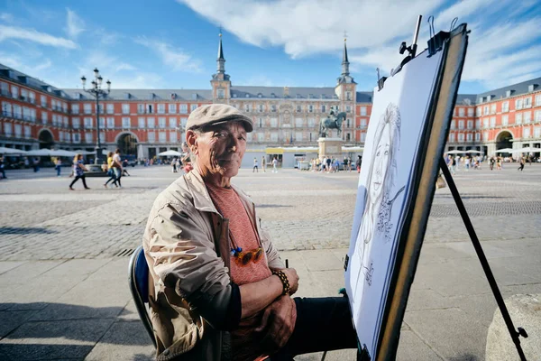 Alter männlicher Straßenmaler zeichnet Porträt eines Touristen — Stockfoto