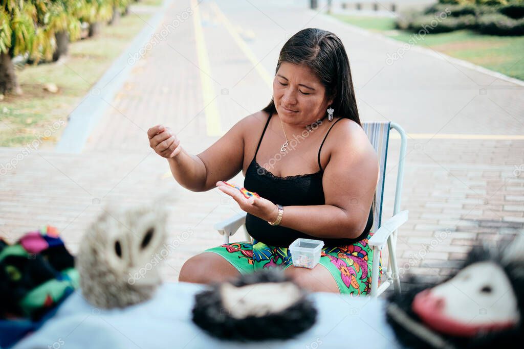 Indigenous Woman Beading Flower Coaster At Market Stall For Tourists