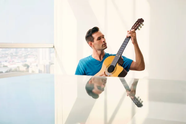 Retrato de homem adulto tocando guitarra clássica e cantando Fotos De Bancos De Imagens