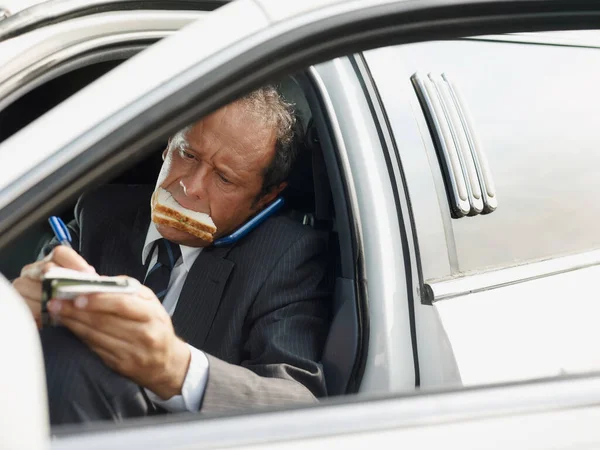 Kierowca białej limuzyny Jedzenie Lunch w samochodzie — Zdjęcie stockowe