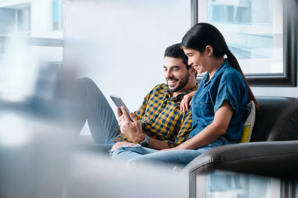 Gelukkig paar lachen tijdens het bekijken van video op tablet — Stockfoto