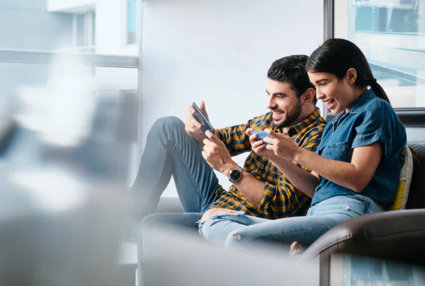 Pessoas felizes jogando videogame com smartphone e rindo — Fotografia de Stock