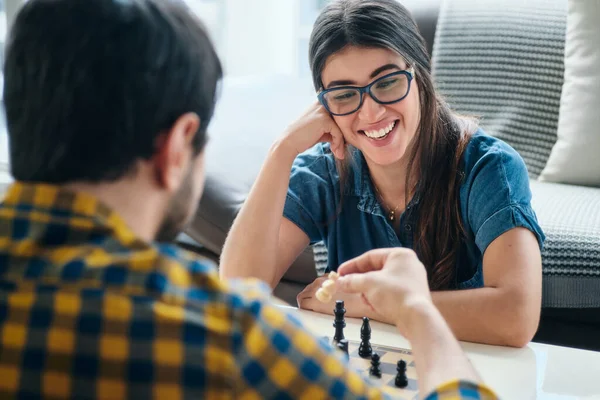Jonge man en vrouw hebben plezier en schaken — Stockfoto