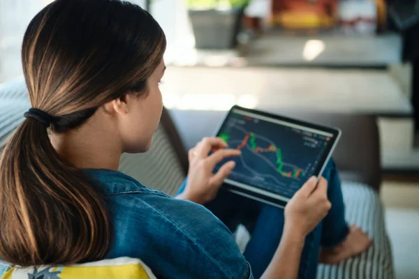 Mujer que negocia en línea usando la computadora de la tableta en sofá — Foto de Stock