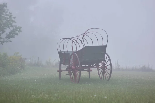 濃霧下の草原でのキャンバ ストップせず コネストーガ幌馬車 — ストック写真
