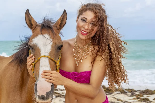 İspanyol ve Latin esmer manken Karayip bir sahilde bir ata biniyor