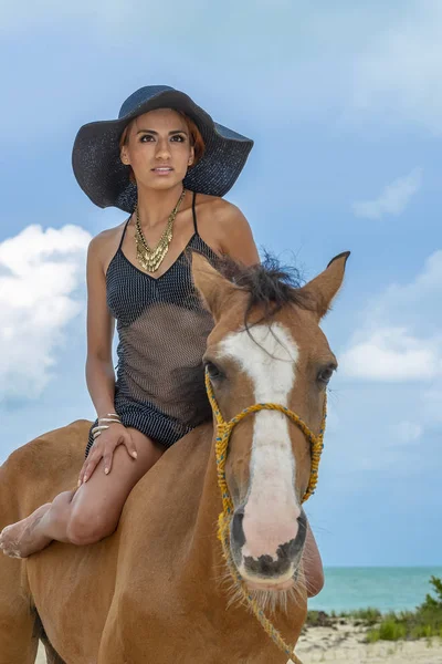 西班牙裔美国人的布鲁内特模型骑着马在加勒比海滩上 — 图库照片