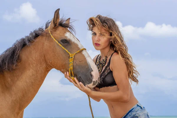 İspanyol ve Latin esmer manken Karayip bir sahilde bir ata biniyor