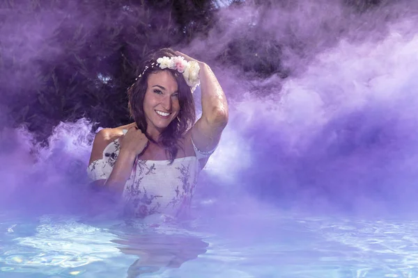 Una Modelo Morena Nadando Una Piscina Con Humo Colores Fondo — Foto de Stock