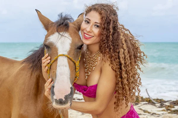 İspanyol ve Latin esmer manken Karayip bir sahilde bir ata biniyor