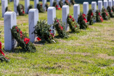 Veterans cemetery adorned with wreaths for the holiday season clipart