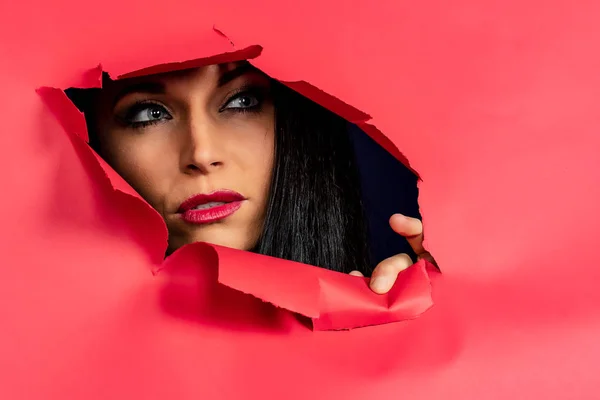 Чудова Брюнетка Модель Проривається Через Рожевий Папір Показуючи Тільки Обличчя — стокове фото
