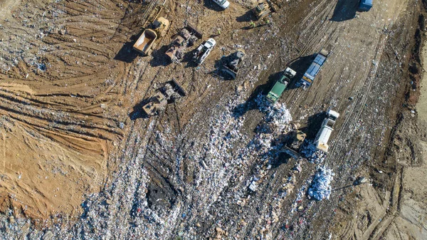 Aerial views of a county trash dump being serviced by multiple dump trucks